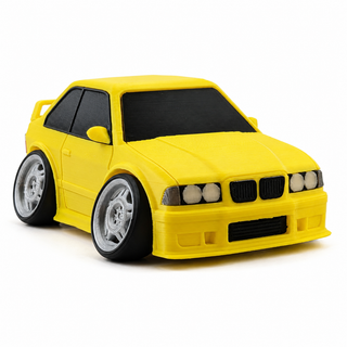 Yellow BMW E36 M3 tooned 3D printed desk model shown from the front three-quarter view on a white background.