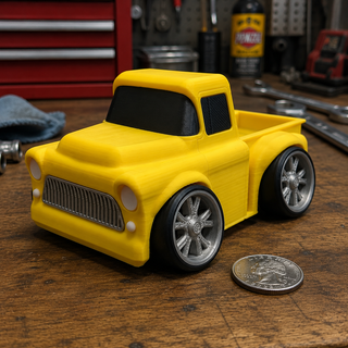 Yellow Classic Pickup Tooned 3D Printed Desk Model displayed on a garage workbench beside a U.S. quarter for scale.