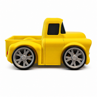 Side view of a yellow Classic Pickup Tooned 3D Printed Desk Model with silver wheels on a white background.