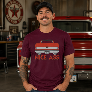 Model wearing a burgundy Nice Ass Red Squarebody T-shirt in a garage with a red classic pickup truck in the background.