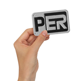 Front-view mockup of the Sergio Perez Cadillac Color Bar F1 embroidered patch in the black variant, shown held in hand against a light background.