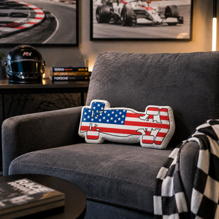 USA flag formula racing car custom-shaped pillow on a gray lounge chair in a motorsport-themed room